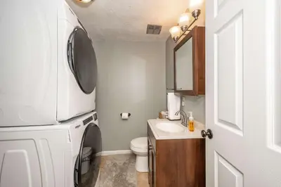 a small bathroom with a sink and a washer and dryer at Cozy Home Away From Home in Florence