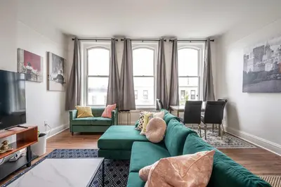 a living room with a green couch and two chairs at The Heart of Madison 3 in Covington