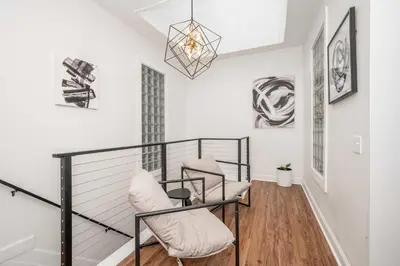 a balcony with two chairs and a chandelier at The Heart of Madison 3 in Covington