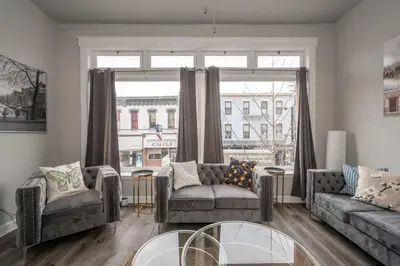 a living room with two couches and a large window at The Heart of Madison Suites in Covington