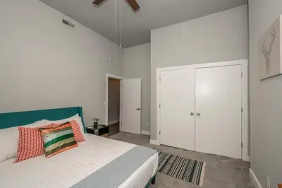 a white bedroom with a bed and a white closet at The Heart of Madison Suites in Covington