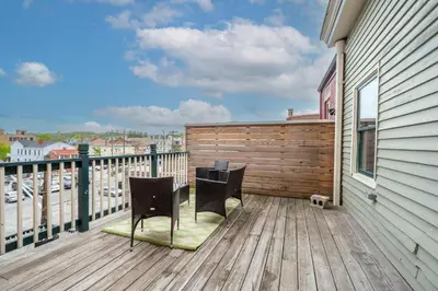 a balcony with two chairs on a wooden deck at The Heart of Madison Suites in Covington