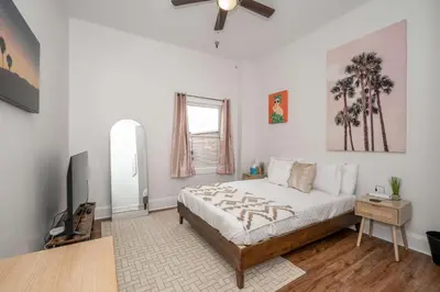 a white bedroom with a bed and a window at The Heart of Madison Suites in Covington