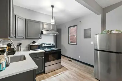 a kitchen with a stainless steel refrigerator and cabinets at North Pearl Residences 874 in Columbus