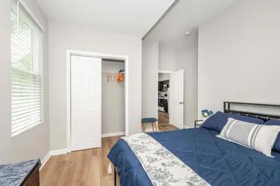 a bedroom with a blue bed and a window at Queen City Retreat 1 Cozy Home for 6 Near Attractions & Restaurants in Cincinnati