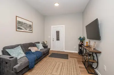 a living room with a couch and a flat screen tv at Queen City Retreat 1 Cozy Home for 6 Near Attractions & Restaurants in Cincinnati