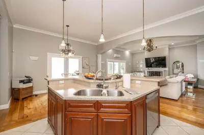 a kitchen with a sink and a living room at The Bishops Manor Stay for 10 in West Chester