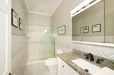 a bathroom with a sink and a toilet and a mirror at The Bishops Manor Stay for 10 in West Chester