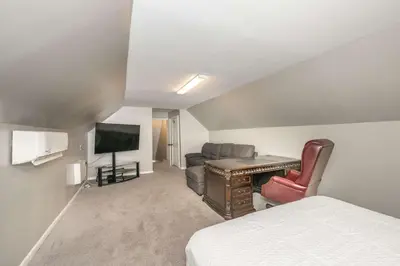 a hotel room with a bed and a desk and a tv at The Bishops Manor Stay for 10 in West Chester