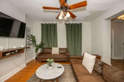 a living room with a couch and a ceiling fan at La Dolce Vita Retreat w Hot Tub in Columbus