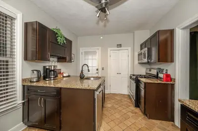 a kitchen with wooden cabinets and a counter top at La Dolce Vita Retreat w Hot Tub in Columbus