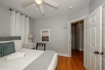 a white bedroom with a bed and a ceiling fan at La Dolce Vita Retreat w Hot Tub in Columbus