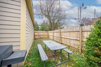 a picnic table and a bench next to a fence at La Dolce Vita Retreat w Hot Tub in Columbus