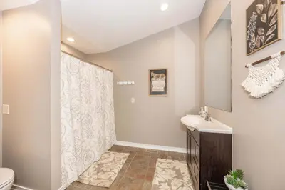 a bathroom with a shower and a toilet and a sink at Main Street Cottage For 6 in Monroe