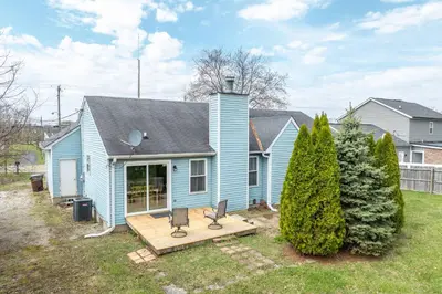 a blue house with a deck in the yard at Main Street Cottage For 6 in Monroe