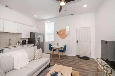 a living room with a couch and a kitchen at Covington Charm 202 in Covington