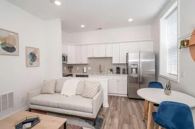 a living room with a couch and a kitchen at Covington Charm 202 in Covington
