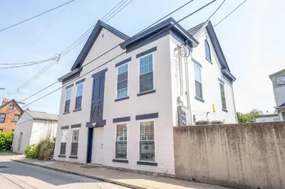 a white house with blue trim on a street at Covington Charm 101 in Covington