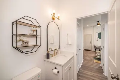 a white bathroom with a sink and a mirror at New Listing - Covington Charm Suites in Covington