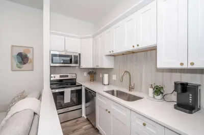 a kitchen with white cabinets and a sink at New Listing - Covington Charm Suites in Covington