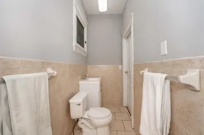 a bathroom with a toilet and a shower with towels at Suites on Main 1 in Covington