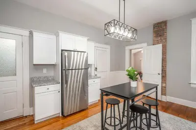 a kitchen with a black table and a refrigerator at Suites on Main 1 in Covington