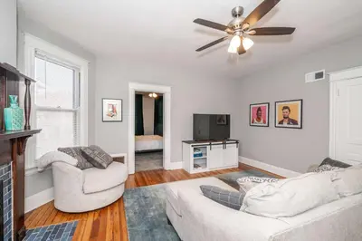 a living room with two couches and a ceiling fan at Suites on Main 2 in Covington