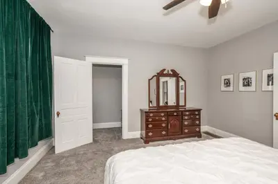 a bedroom with a bed and a mirror and a dresser at Suites on Main 2 in Covington