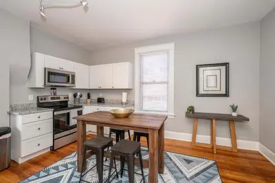 a kitchen with a wooden table and some chairs at Suites on Main 2 in Covington