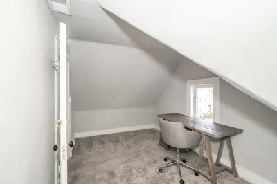 a desk and a chair in a room with an attic at Suites on Main 3 in Covington