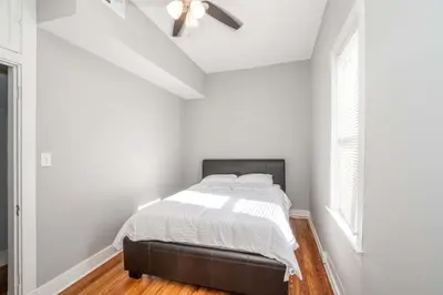 a bedroom with a bed and a ceiling fan at Suites on Main 3 in Covington