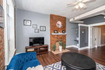 a living room with a blue couch and a fireplace at New Monmouth Loft 1 - City Chic 1 BDR in Newport