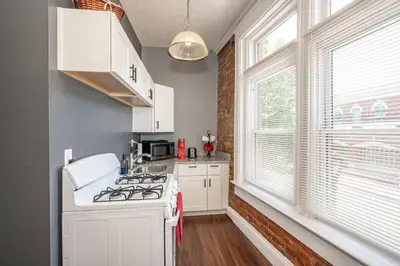 a kitchen with a white stove top oven next to a window at New Monmouth Loft 1 - City Chic 1 BDR in Newport