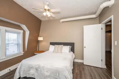 a bedroom with a white bed and a ceiling fan at Monmouth Loft 3 - Heart of Newport in Newport