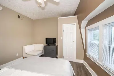 a bedroom with a bed and a chair and a television at Monmouth Loft 3 - Heart of Newport in Newport