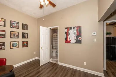 a living room with a ceiling fan and paintings on the wall at Monmouth Loft 3 - Heart of Newport in Newport