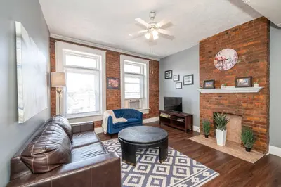 a living room with a leather couch and a fireplace at Monmouth Lofts - Newport Lofts Sleep 10 in Newport