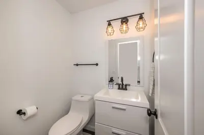a white bathroom with a toilet and a sink at Lark Meadow Retreat Sleeps 10 in Mason