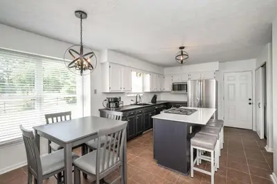 a kitchen with white cabinets and a table and chairs at Lark Meadow Retreat Sleeps 10 in Mason