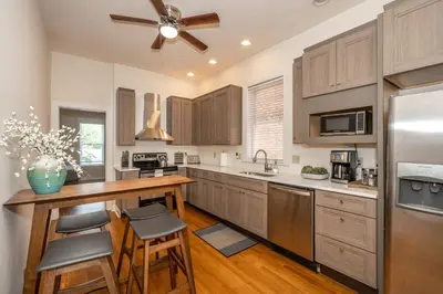 a kitchen with wooden cabinets and a ceiling fan at Cityscape Escape - Local Eateries in Cincinnati