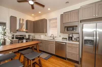 a kitchen with a wooden table and stainless steel appliances at Cityscape Escape - Local Eateries in Cincinnati