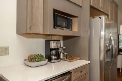 a kitchen with a counter with a coffee maker and a refrigerator at Cityscape Escape - Local Eateries in Cincinnati