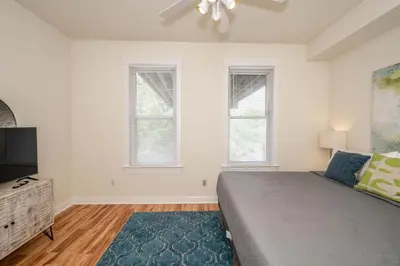 a bedroom with a bed and a flat screen tv at Cityscape Escape - Local Eateries in Cincinnati