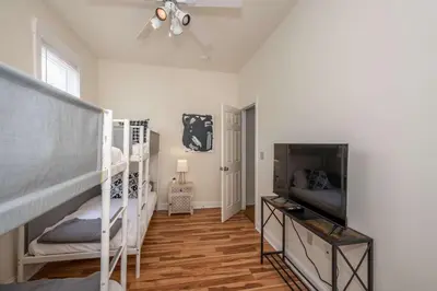 a bedroom with two bunk beds and a flat screen tv at Cityscape Escape - Local Eateries in Cincinnati