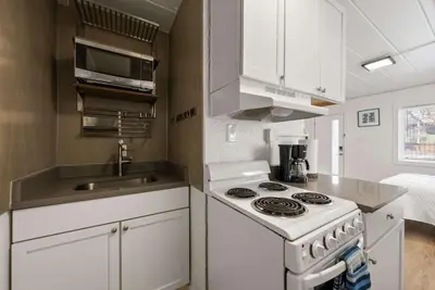 a white kitchen with a stove and a sink at Chic City Retreat 89 For 2 in Columbus