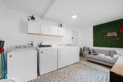 a laundry room with white appliances and a couch at Chic City Retreat 89 For 2 in Columbus