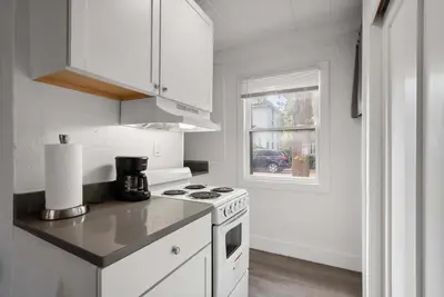 a white kitchen with a stove and a window at Chic City Retreat 93I in Columbus