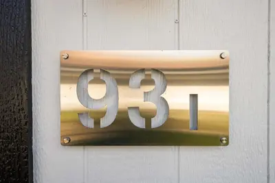 a sign on a white wall with the number at Chic City Retreat 93I in Columbus