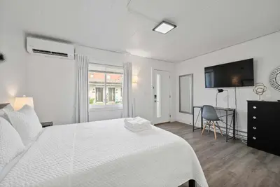 a white bedroom with a white bed and a desk at Chic City Retreat 93I in Columbus