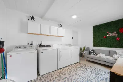 a laundry room with white appliances and a couch at Chic City Retreat 87 in Columbus